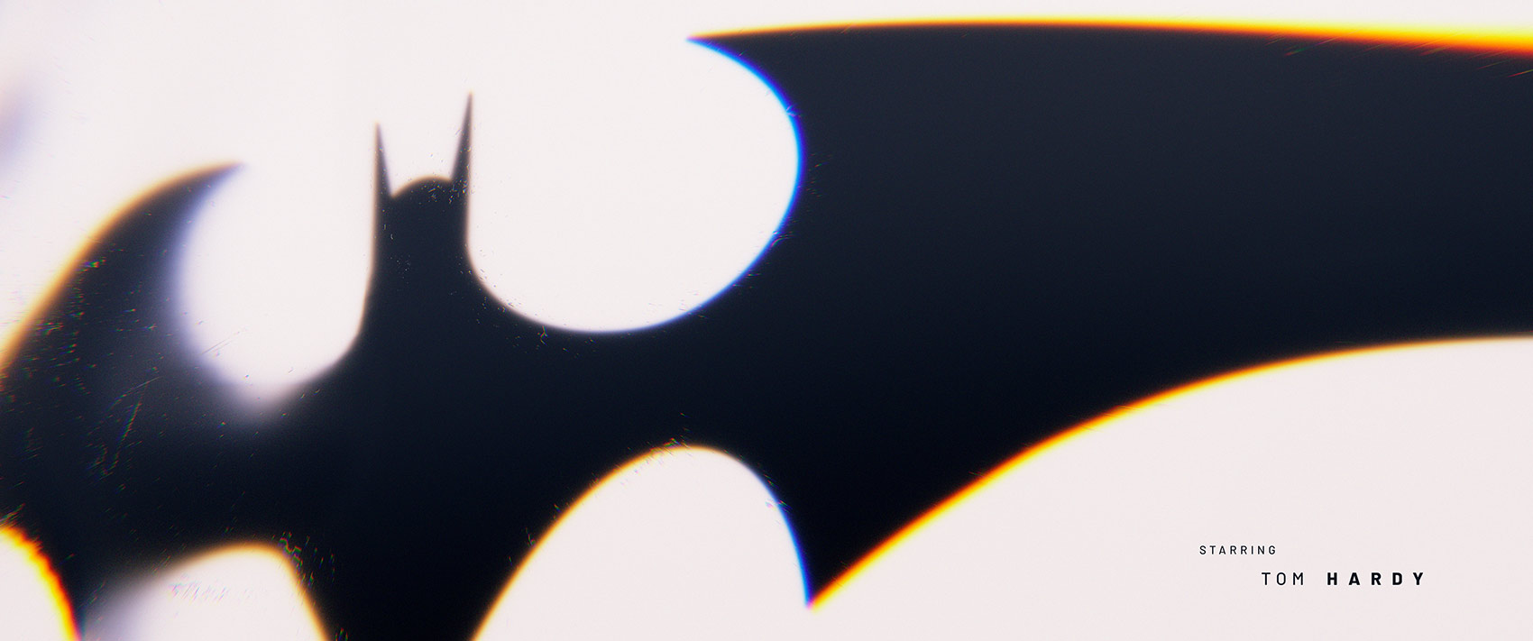 A high-contrast style frame displaying a large, silhouetted Batman emblem with heavy lens blur and chromatic aberration along its edges, balanced by a placeholder starring credit layout in the lower right.