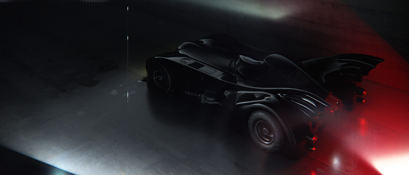 A dramatic high-angle three-quarter rear render of the Batmobile asset under a sharp vertical spotlight, highlighting the smooth black body panels, the rear exhaust nozzles, and glowing red tail lights casting a soft illumination on the floor.