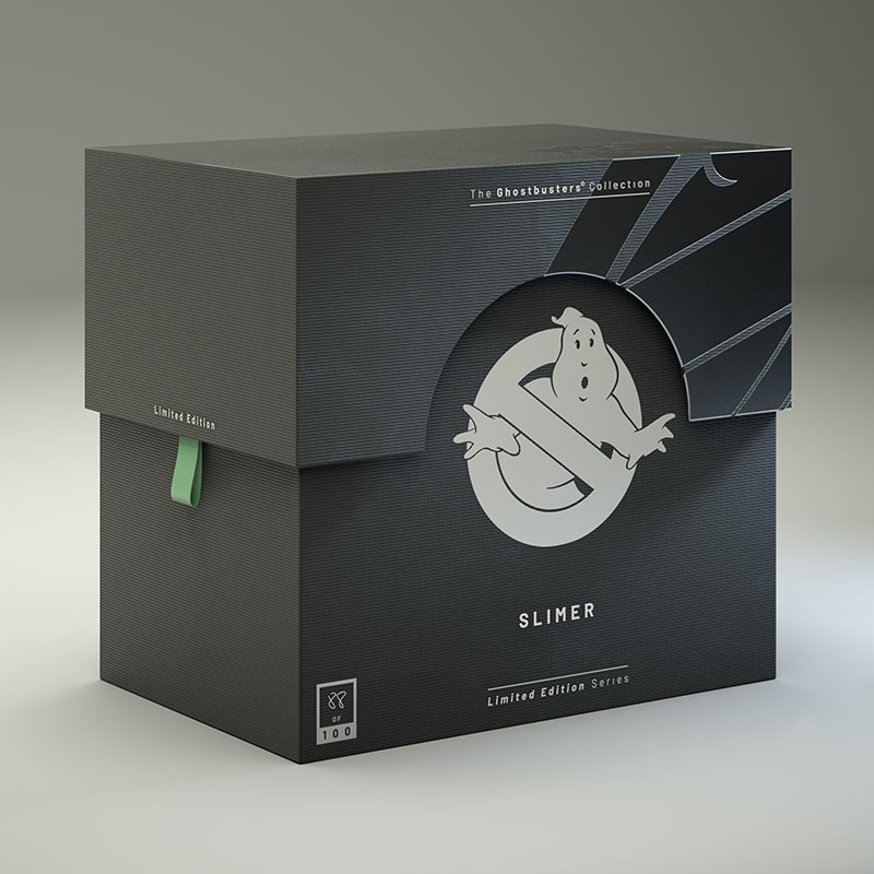 A 3D render of the custom Ghostbusters collectible packaging box, showing the textured matte black surface, a silver foil no-ghost logo emblem, and a green fabric pull tab on the side.