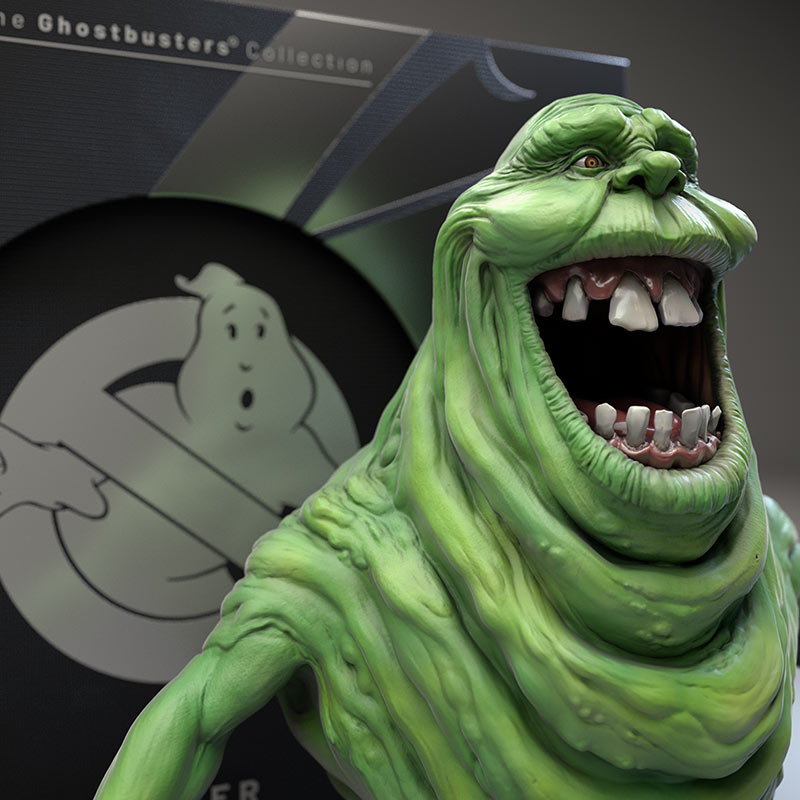 A three-quarter view render of the Slimer character model with the classic Ghostbusters no-ghost emblem visible on the product box behind the figure.