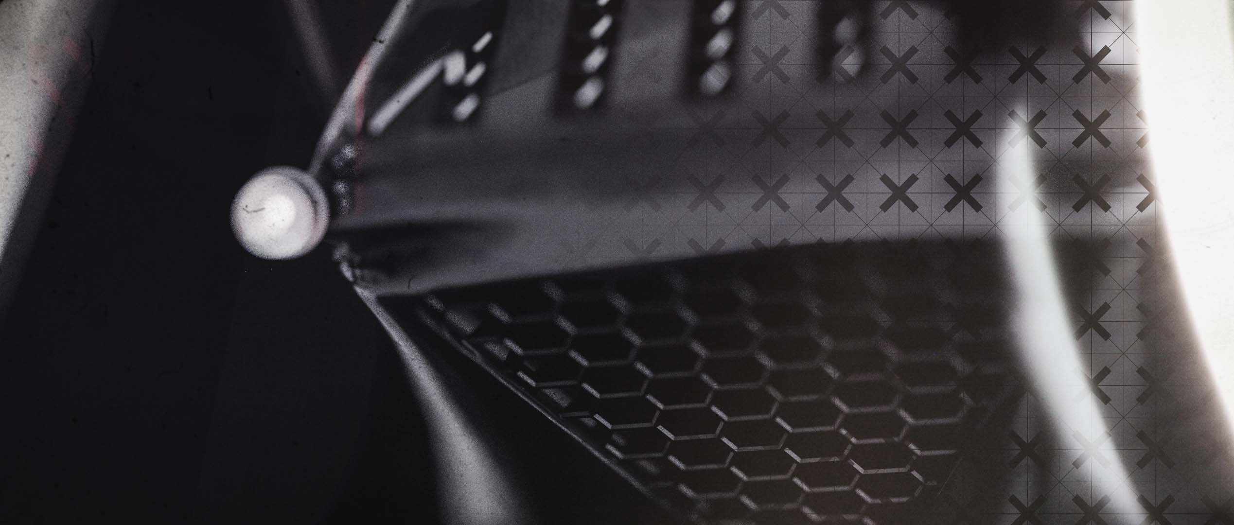 A high-contrast monochrome macro render focusing on a curved, dark metallic surface structure, overlaid with a graphic crosshair alignment pattern and hit by a bright, vertical light leak streak.