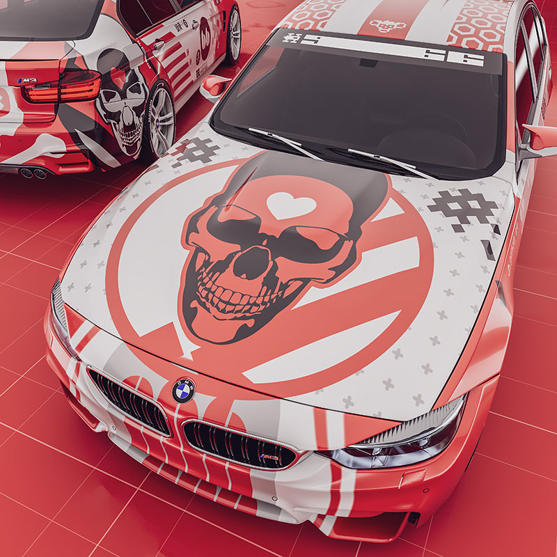 An overhead three-quarter render focusing on the front hood of the car, showcasing a large red skull graphic emblem with a heart symbol on the forehead over a striped pattern backdrop.
