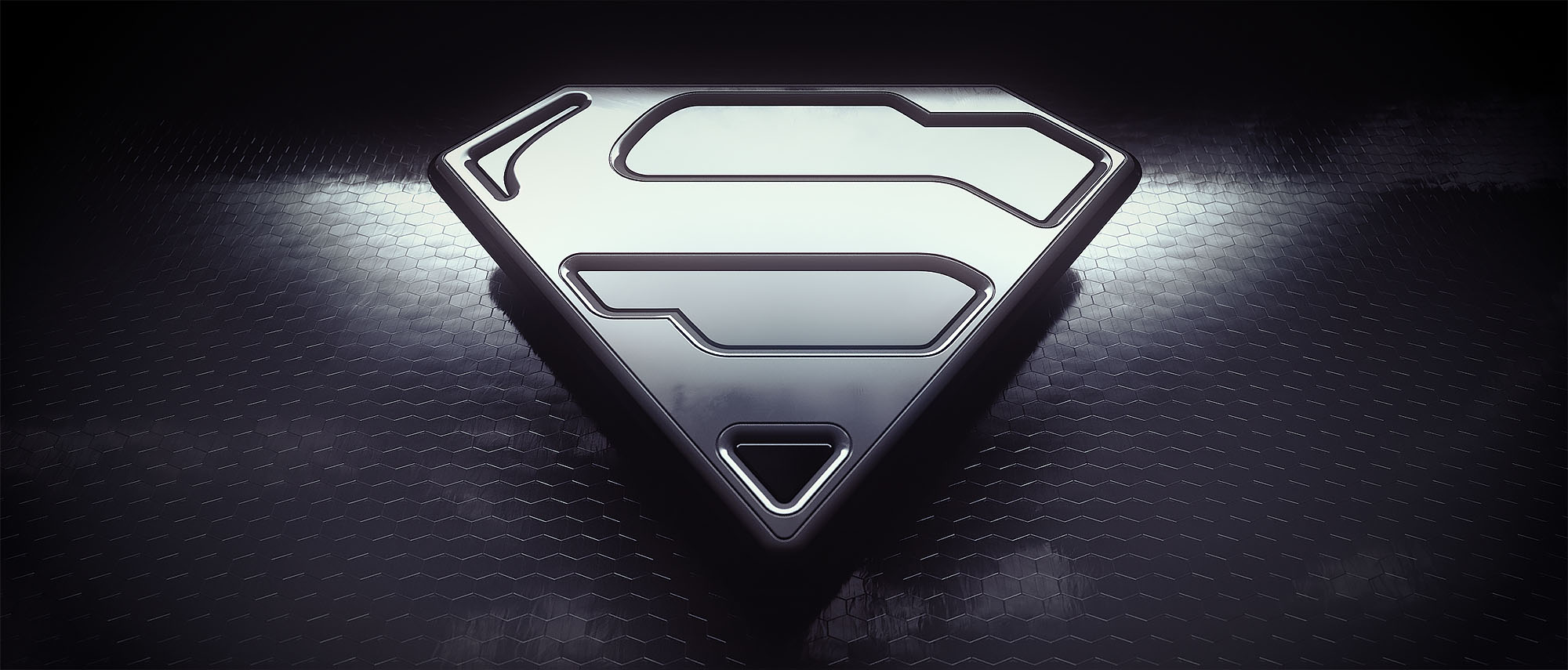 A monochromatic 3D render of the contemporary Superman shield emblem with a polished chrome finish, resting on a dark, textured hexagonal surface under moody studio lighting.