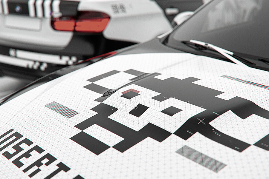 A tight perspective view across the car's front hood, demonstrating how the pixel art skull graphic sits on the curved panel next to the windshield.