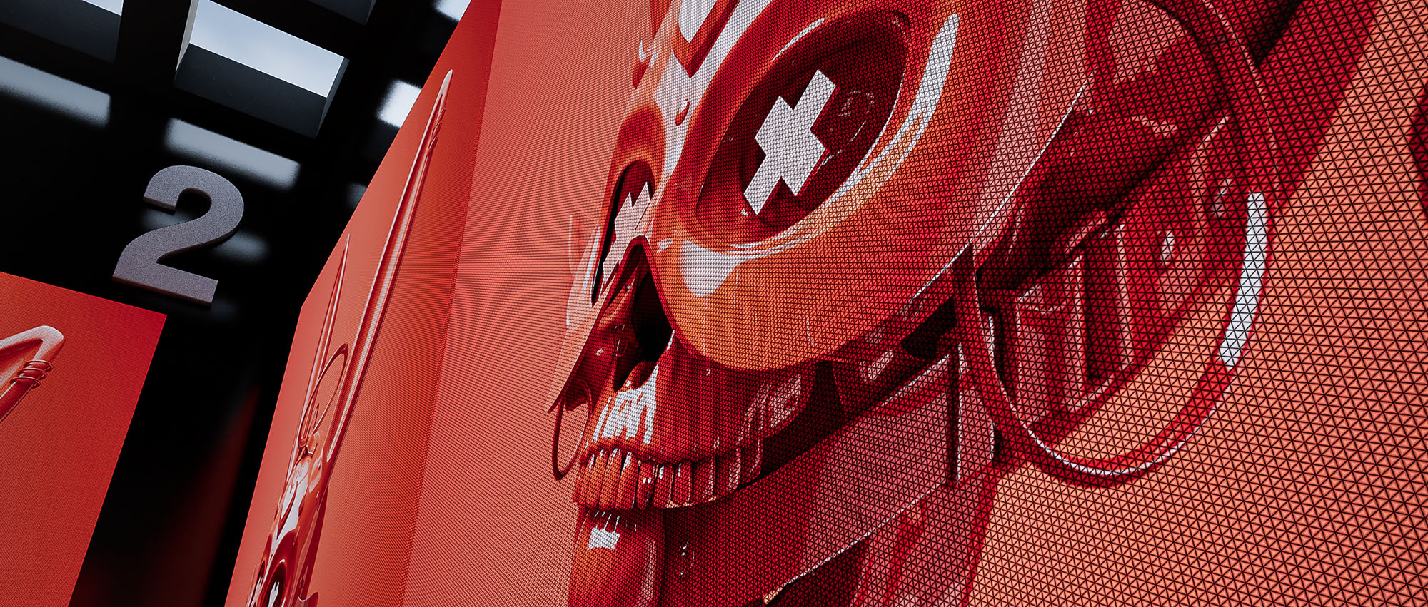 A detailed close-up shot from image_ab43c0.jpg focusing on a vibrant red textured skull artwork mounted on an interior gallery wall next to a large silver room number two indicator.