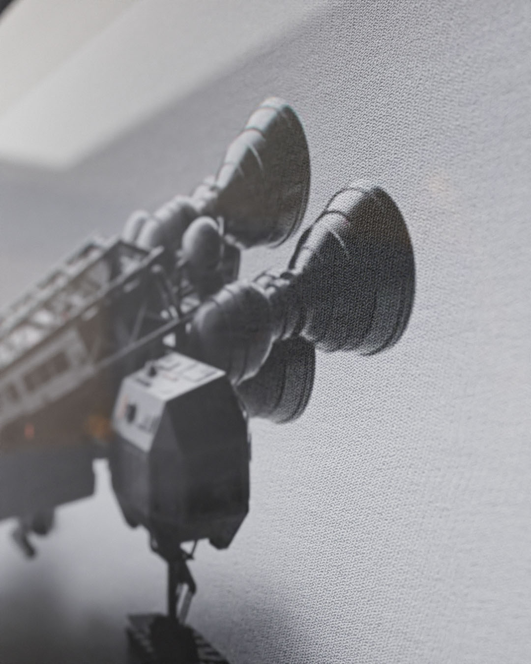 A close-up black-and-white architectural study focusing on the rear propulsion thruster assembly of the Eagle Transporter model, stylized with heavy grain and a shallow depth of field to mimic physical model photography.