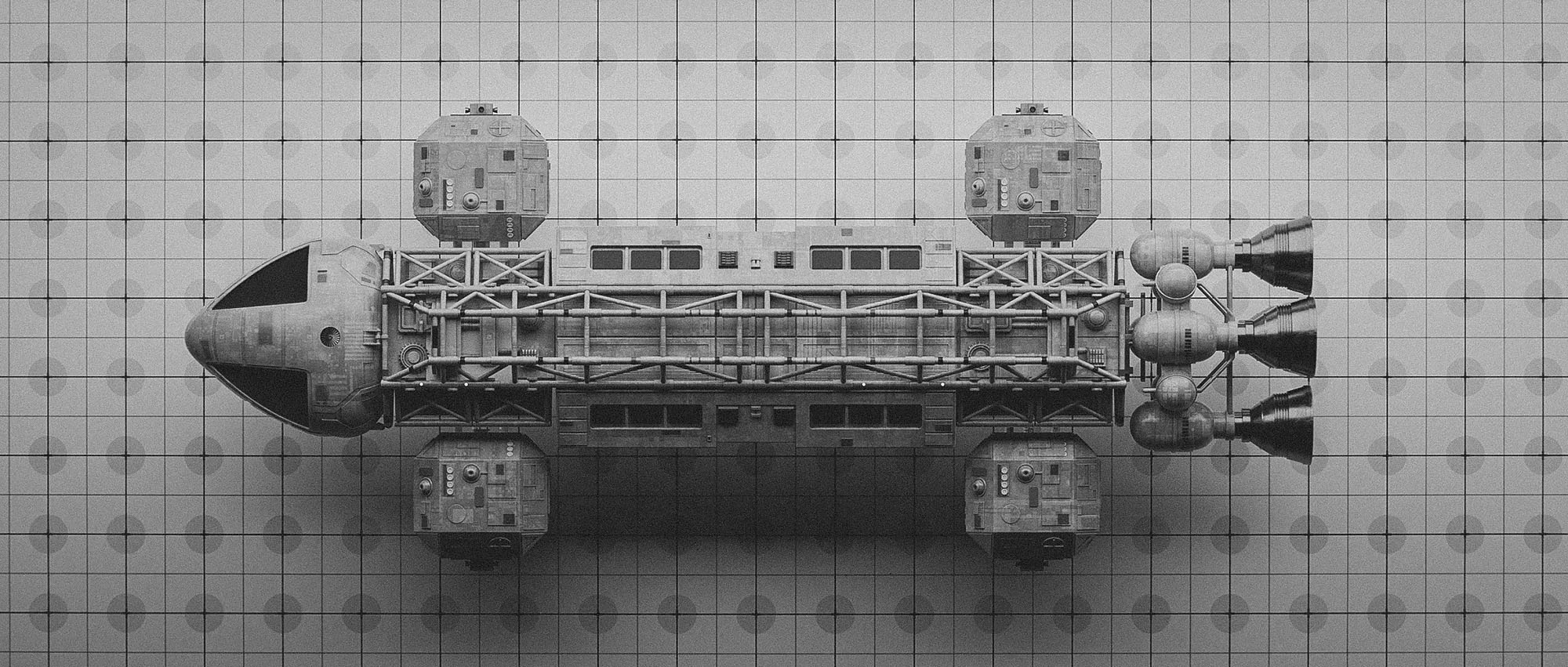 A black-and-white orthographic top-down layout of a single Eagle Transporter centered on a technical drafting grid mat, showing the full longitudinal framework and modular panel placement.