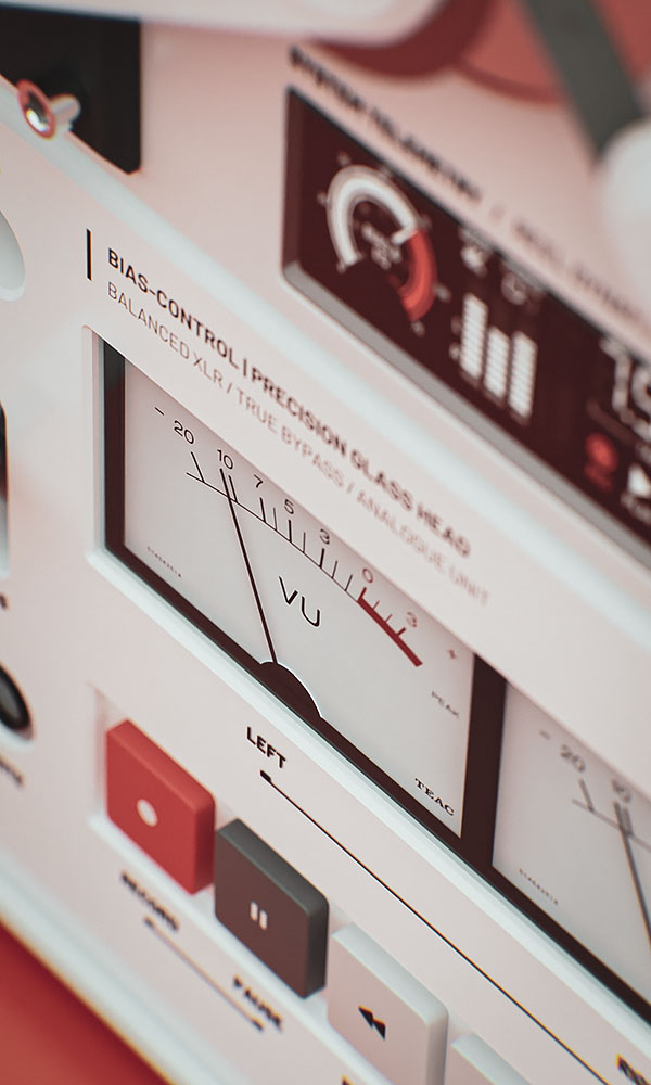 Detailed close-up view of the dual mechanical VU meters, system readouts, and physical playback interface keys on the product mockup.