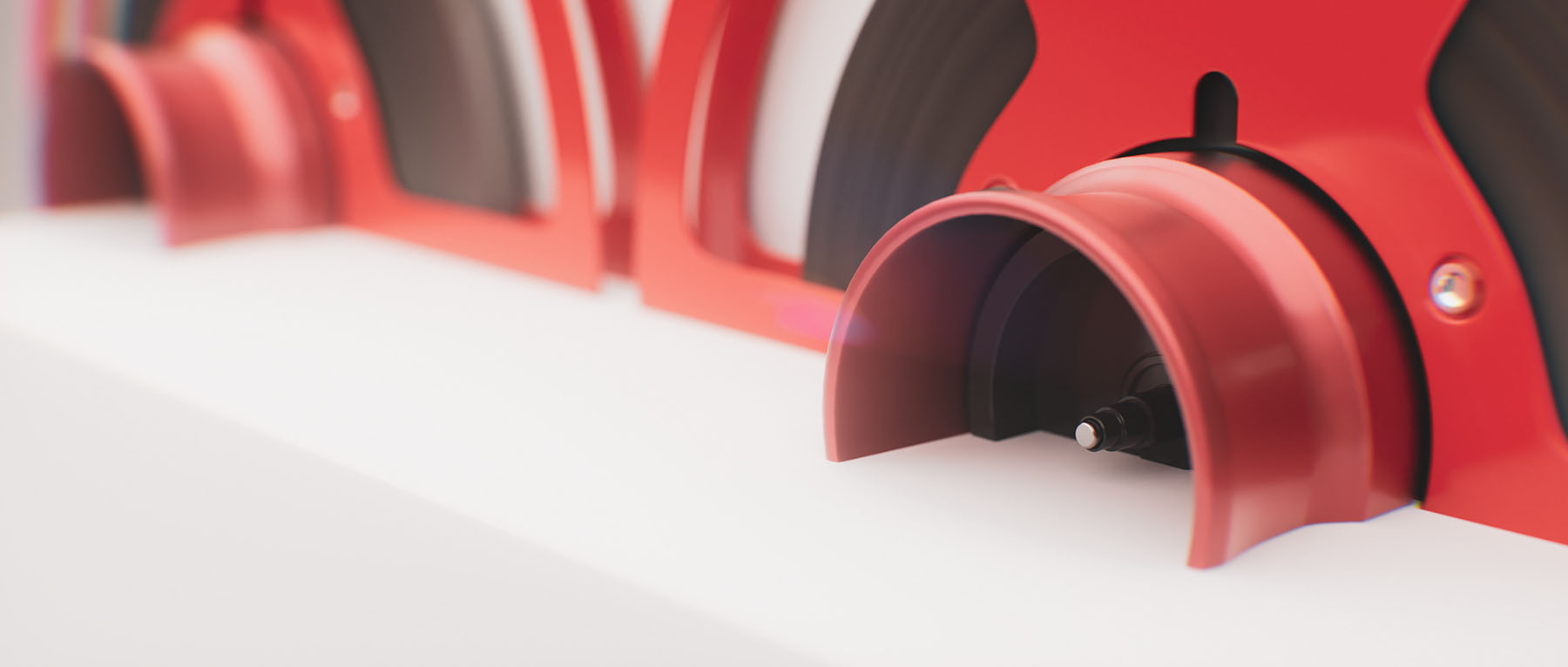 Macro view of the lower reel assembly mechanics on the audio recorder focusing on clean industrial material cuts and a curved red housing unit.