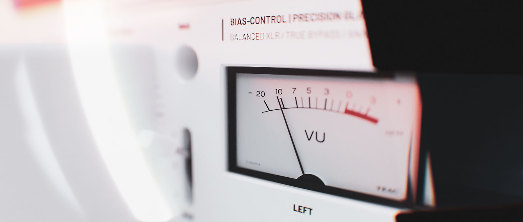 Cinematic macro view focusing closely on the left-channel analogue VU meter indicator needle under high-contrast studio illumination.