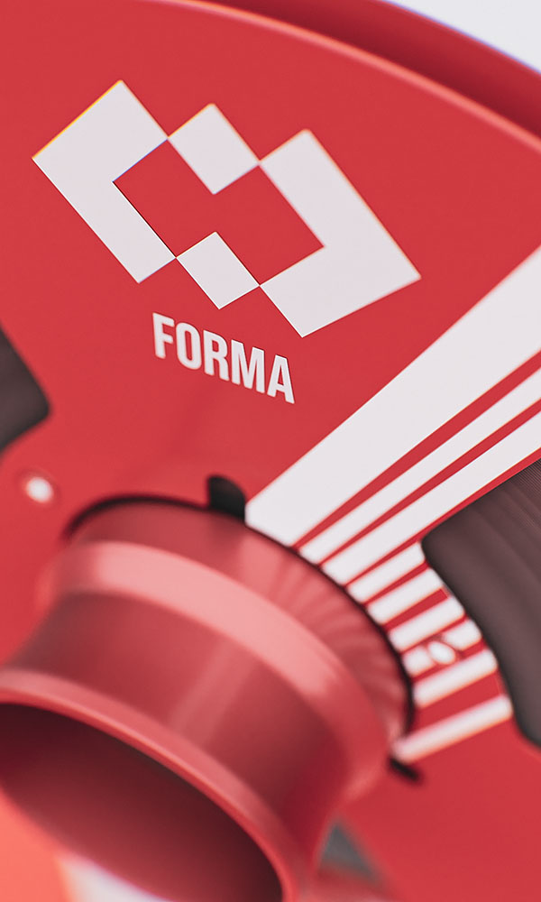Close-up abstract framing of a red metallic audio reel showcasing white graphic stripe patterns and the minimalist corporate logo.